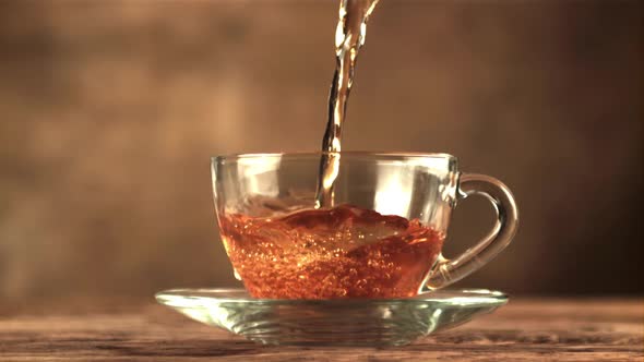 A Super Slow Motion Jet of Tea Pours Into a Cup of Air Bubbles alt