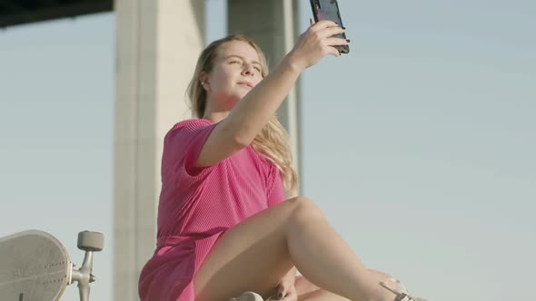 Cute Girl Taking Selfie on Phone After Skateboarding in Park alt