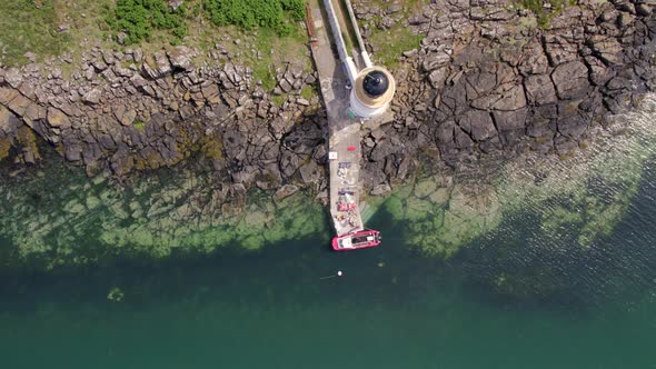 A Ferry Moored at a Jetty and Lighthouse Delivering Cargo and Goods alt