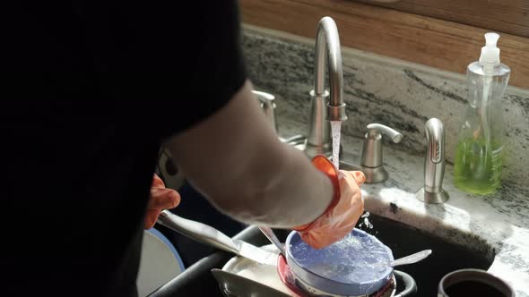Hands in Orange Gloves Wash Dishes in the Kitchen Version 5 alt