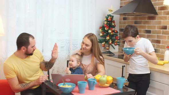 Young Parents and Children Have Meal in Kitchen alt