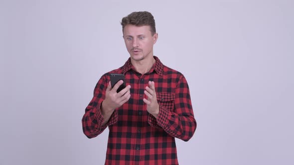 Stressed Bearded Hipster Man Using Phone and Getting Bad News alt