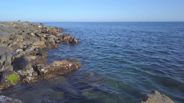 Sea cliff rocks at sunny day aerial view alt
