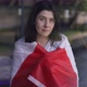 Happy Woman Wrapping in Canadian Flag Looking at Camera Smiling Standing Indoors - VideoHive Item for Sale