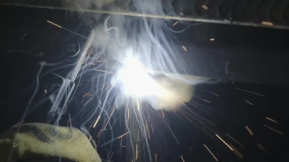 Close-up hand of Metal welder working with an arc welding machine. alt