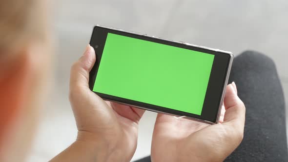 Blonde Caucasian female and  green screen smart phone 4K 2160p 30fps UHD footage - Blond woman holdi alt