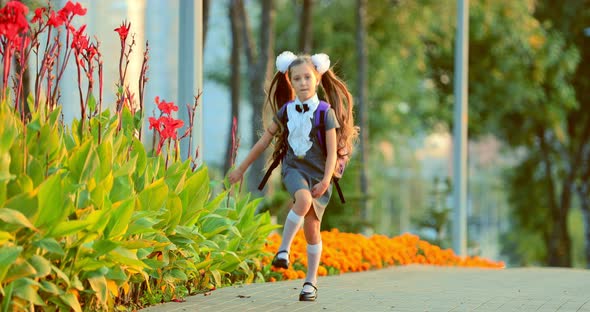 Beautiful School Girl Jumping in the Park alt