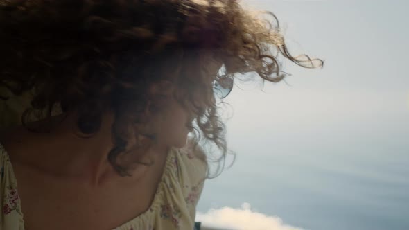 Laughing Girl Shaking Head Sitting Beach in Front Ocean Close Up alt