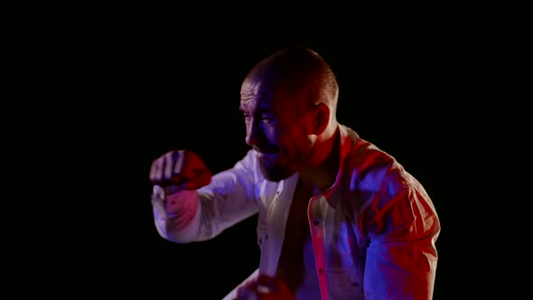 Middleaged Man in Unfastened Shirt is Fighting Alone in Night Portrait Shot alt