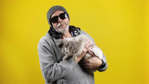Old hipster man with a bunny on hands alt