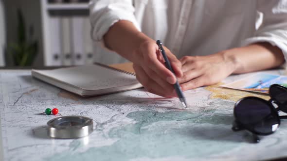 Girl Traveler Plans A Trip On A World Map Globe, Recording Coordinates In A Diary, Planning alt
