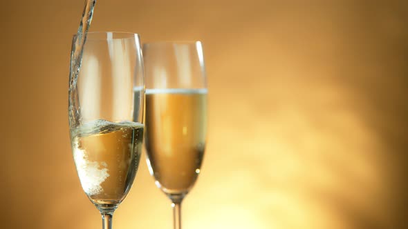 Super Slow Motion Shot of Pouring Champagne on Golden Luxury Background at 1000Fps. alt