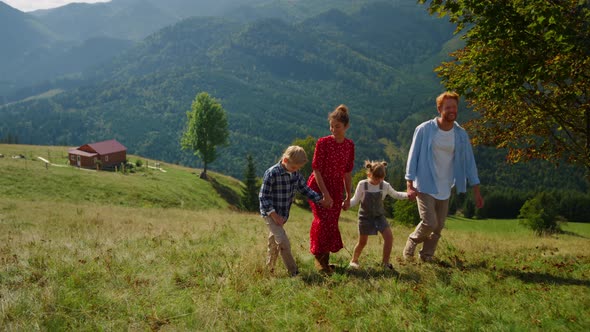 Carefree Family Walk Together on Green Slope alt