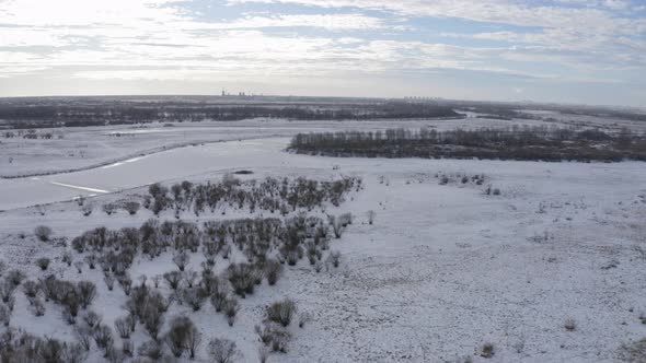 A Fisherman Fishing in Winter Time on Ice Covered River