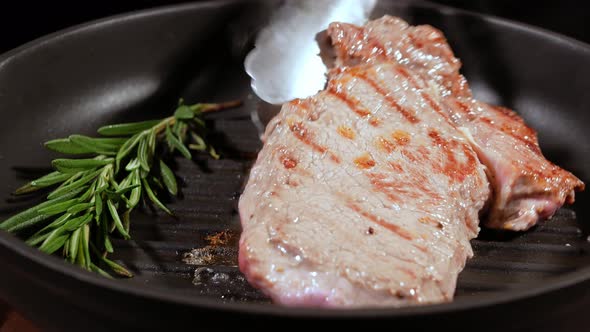 Juicy Meat Steak Is Turned on the Other Side for a Complete Frying.