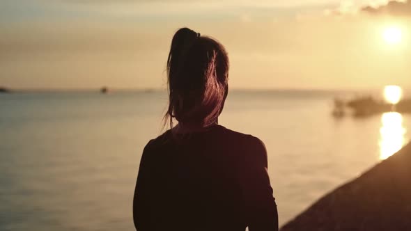 Athletic Woman with Waving Hair Running on Beach at Dramatic Sun alt