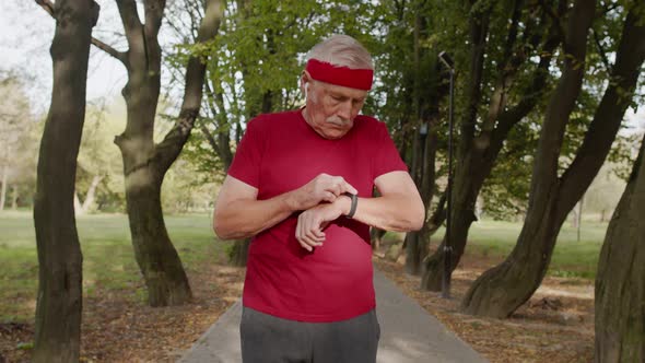 Senior Old Man Running in Park and Using Smart Watch, Tracking Result After Fitness Workout alt