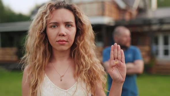 Portrait of Hurt Woman with Scar on Face Showing Secret Gesture of Domestic Violence Victim. Man in alt