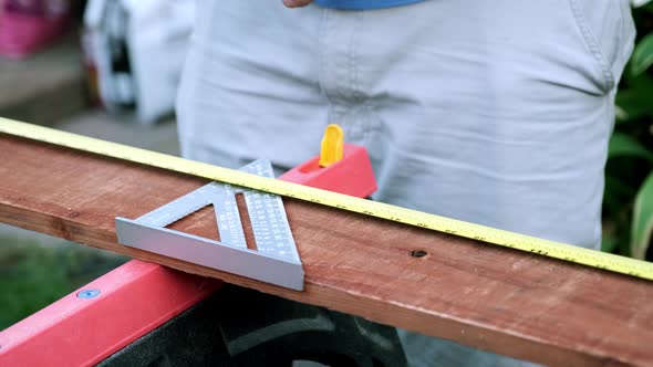 Man in Slow Motion Starting Woodworking Project, Taking Measurements and Preparing Wood alt
