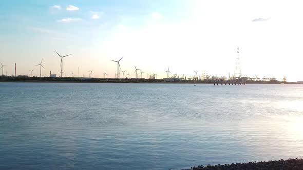 Push-out droneement with an overview of a windmill park at the Antwerp harbour. The footage is made alt