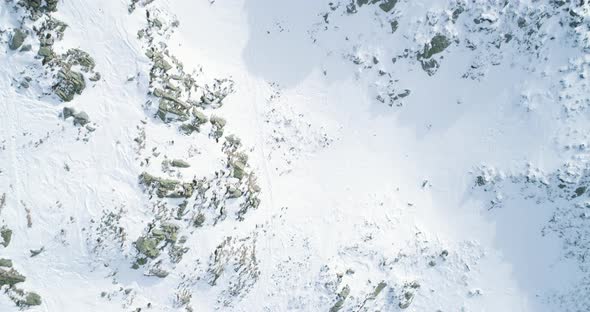 Overhead Aerial Top View Over Winter Snowy Mountain with Mountaineering Skier People Walking Up