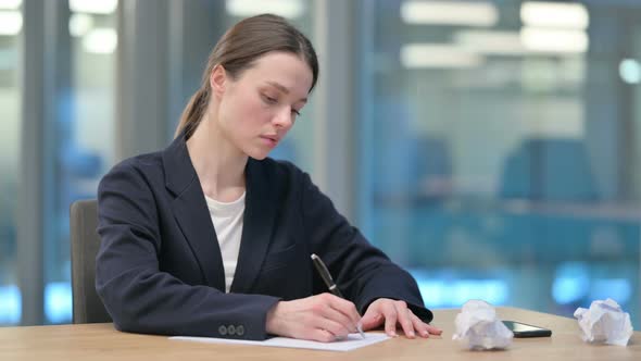 Young Businesswoman Trying to Write on Paper in Office alt