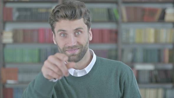 Ambitious Young Man Pointing with Finger and Inviting alt