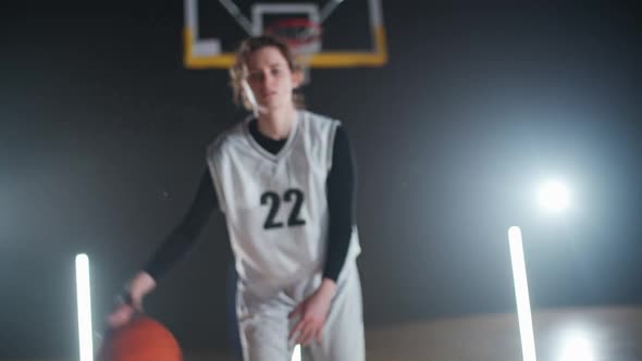 Portrait of Young Female Basketball Player Hits the Ball Off the Floor and Warms Up Before the Game alt