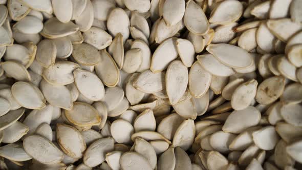 A Lot of Pumpkin Seeds Close Up Rotates Against the Background in a  Store. alt