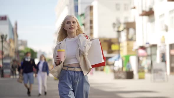 Joyful Attractive Woman Walks with Cardboard Bags From Different Shops