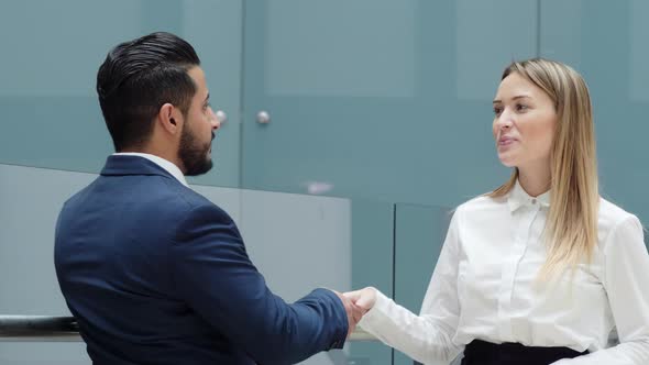 Caucasian businesswoman shaking hands her colleague indoor