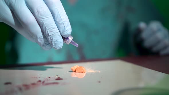 Doctor Hands in Blue Gloves Drop Disapearing Poison on Orange Color Pill in Illegal Secret Medical