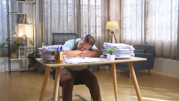 Fat Asian Man Sleeping Due To Working Hard With Documents At The Office alt
