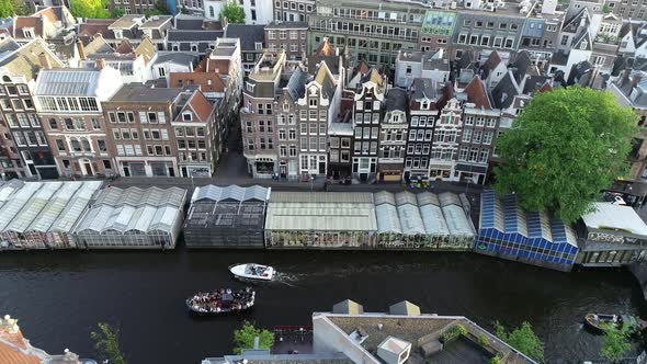 Aerial view of famous Amsterdam canal in Netherlands in 4K. Party boats and typical dutch houses