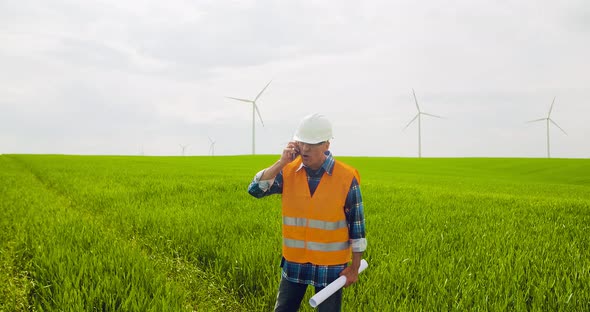 Male Engineer Working While Holding Blueprint alt
