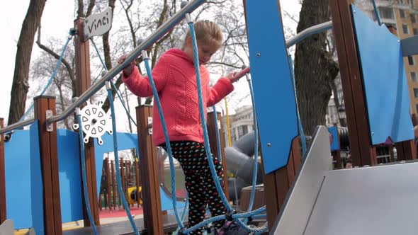 Concentrated Junior Schoolgirl on Suspension Bridge