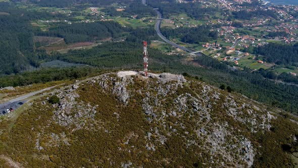 Aerial View Of Telecommunications Mast On Rocky Hillside In Miradoiro da Curota. Dolly Back Shot alt