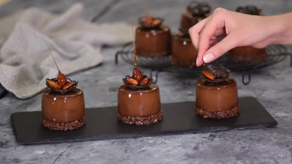Pastry Chef Decorate a Chocolate Mousse Dessert with Caramel Almond alt