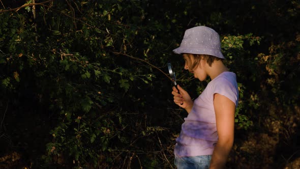 Naturalist Children Girl with Loupe Studying Learning Nature Outside and Makes Notes in Notebook alt