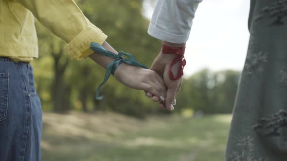 Unrecognizable Man Woman Ribbons Wrists Standing Outdoors alt