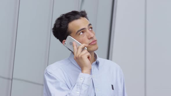 Closeup shot of young businessman talking on cell phone outdoors