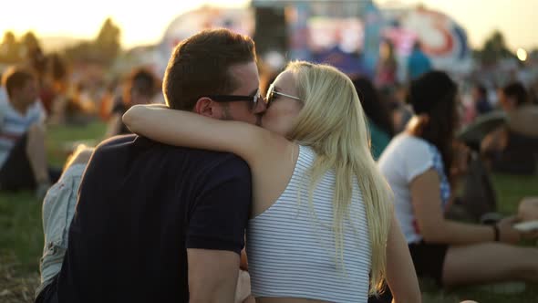 Young Couple Kissing on Summer Festival alt