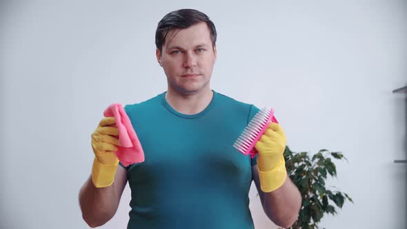 Portrait of a Housekeeper in Yellow Rubber Gloves Holding a Brush and Spray