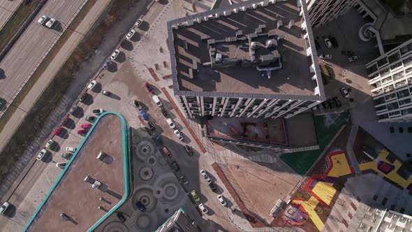 Top Down Flying Over Tall Buildings and a Road with Cars