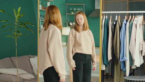 Depressed Red Haired Teenage Girl Looking at Her Reflection in the Mirror alt