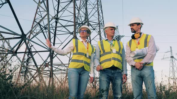 Power Engineers Are Standing Next To Electrical Towers and Talking ...