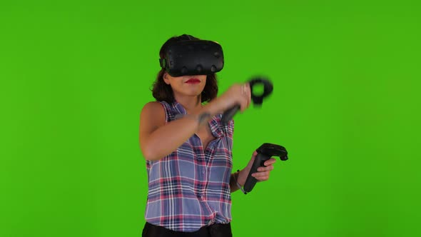Playing Happily in A Vr by A Young Woman Over a Green Screen, Using Remotes, Casual Look alt