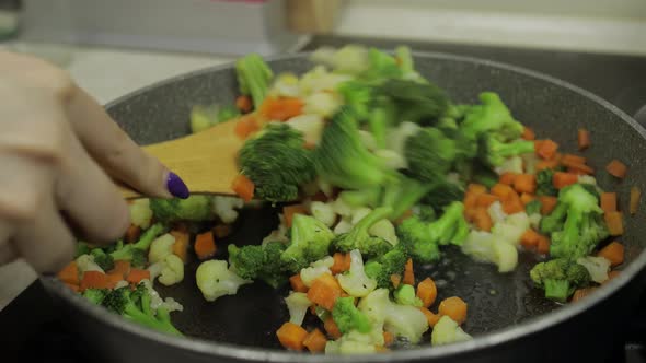 Mixing Fresh Vegetables on Frying Pan. Boiling Carrots, Cauliflower, Broccoli alt
