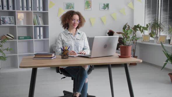 Modern Young Woman with Glasses Examines Online Training and Communicates with Teacher Via Video alt