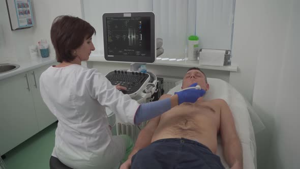 Woman Doctor Makes Heart Check of Patient Man Using Modern Equipment in a Cardiology Clinic alt
